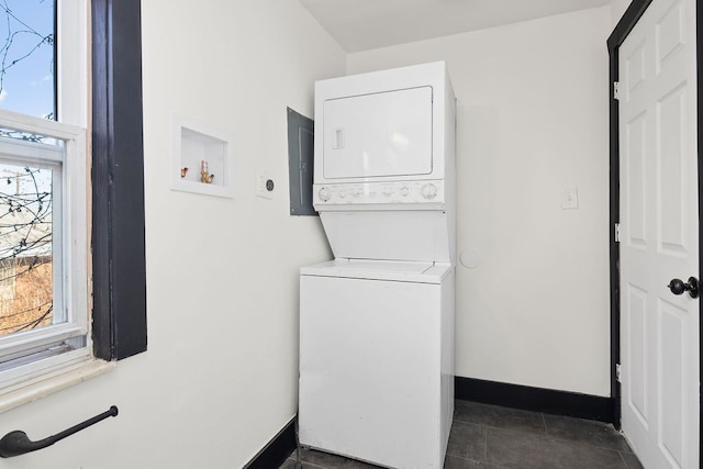 laundry room with electric panel and stacked washer and clothes dryer