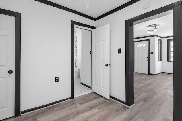 corridor featuring light hardwood / wood-style flooring and crown molding