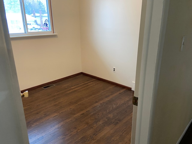 empty room featuring dark hardwood / wood-style flooring