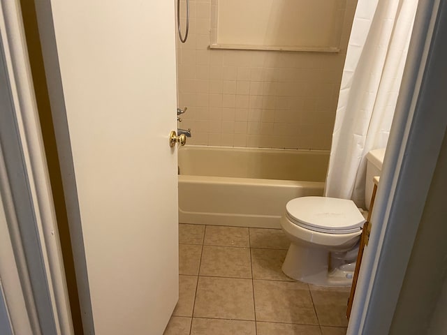 bathroom with tile patterned floors, shower / bathtub combination with curtain, and toilet