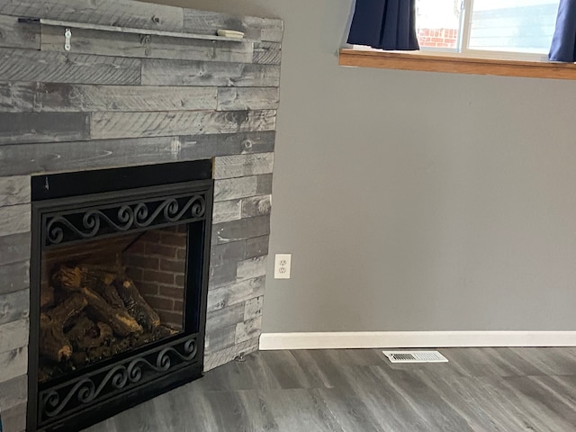 interior details with a stone fireplace and hardwood / wood-style flooring