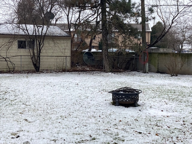 yard layered in snow featuring an outdoor fire pit