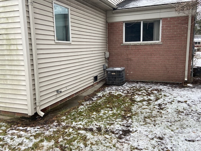 view of snowy exterior with central air condition unit