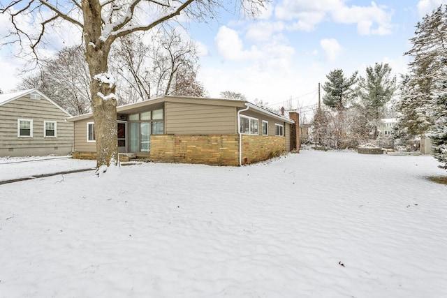 view of snow covered back of property