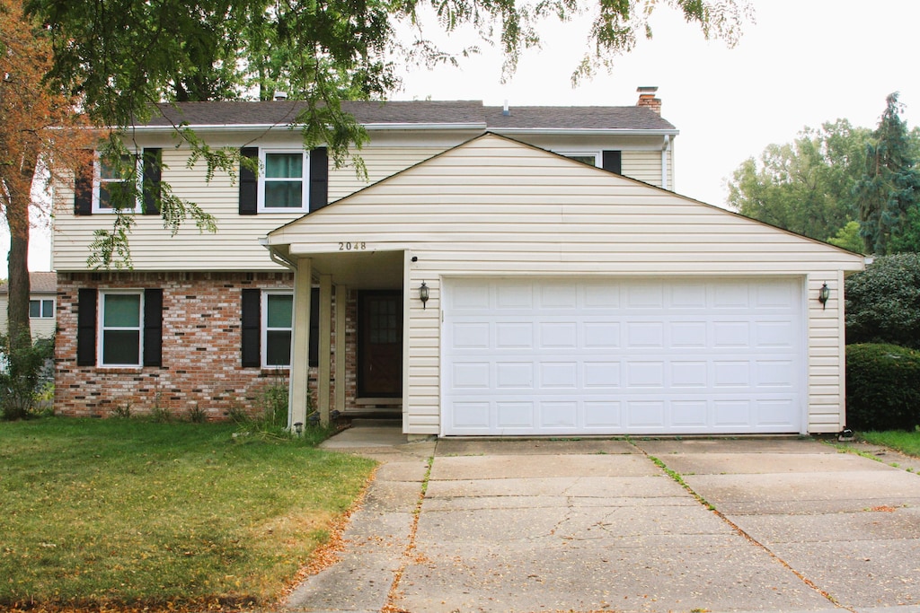 view of front of property featuring a front yard and a garage