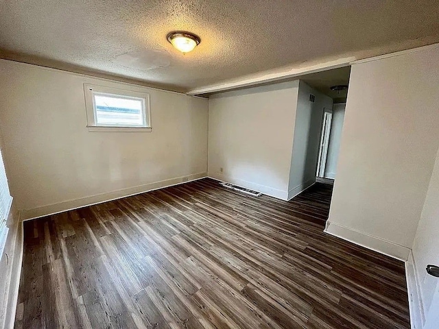 spare room with dark hardwood / wood-style flooring and a textured ceiling