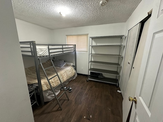 unfurnished bedroom featuring a textured ceiling and dark wood-type flooring