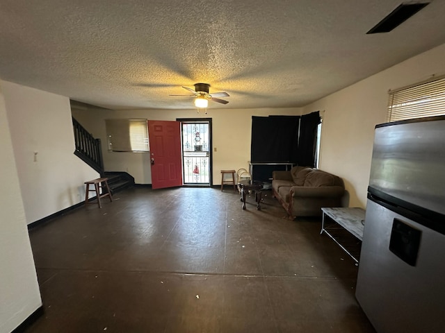 living room with a textured ceiling and ceiling fan