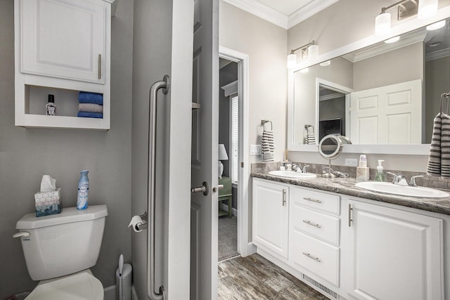 bathroom with hardwood / wood-style floors, vanity, toilet, and ornamental molding