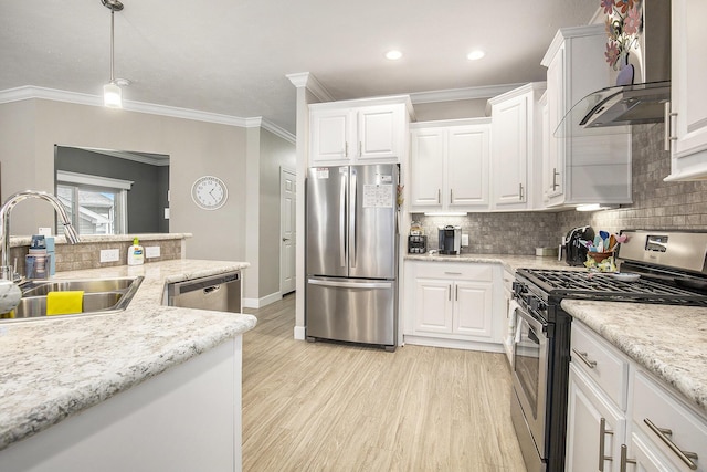 kitchen featuring pendant lighting, sink, wall chimney exhaust hood, white cabinetry, and stainless steel appliances