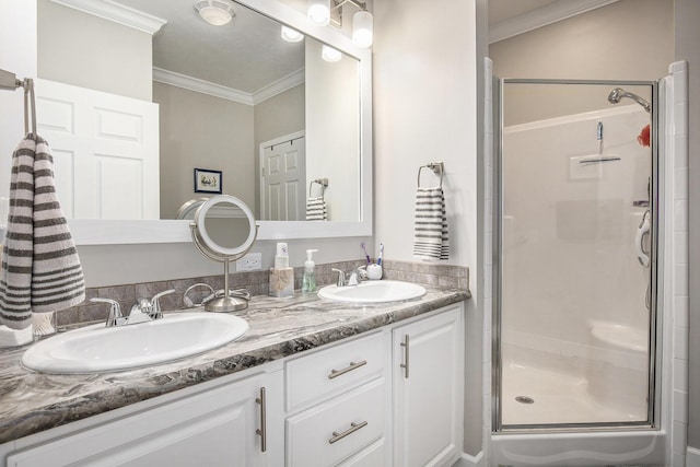 bathroom featuring vanity, a shower with shower door, and ornamental molding