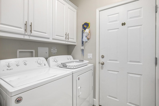 laundry room featuring separate washer and dryer and cabinets