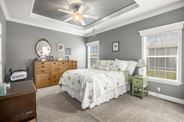 carpeted bedroom featuring a raised ceiling, ceiling fan, and ornamental molding