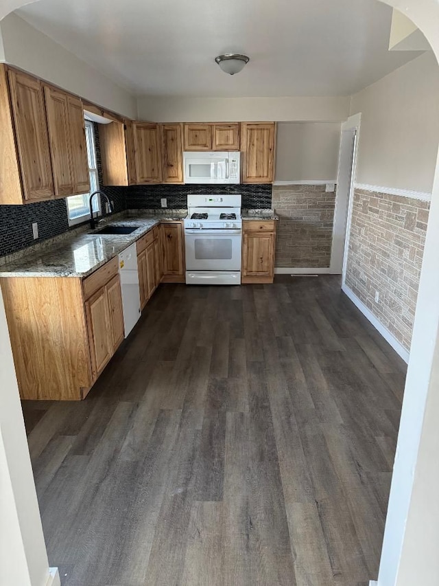 kitchen featuring white appliances, stone countertops, dark hardwood / wood-style floors, and sink