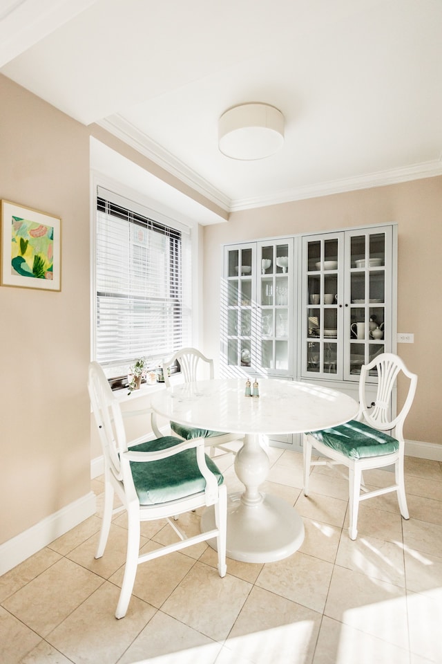 tiled dining space featuring ornamental molding