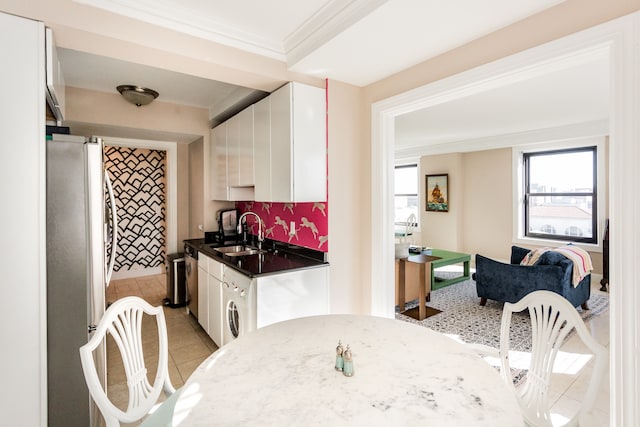 kitchen featuring decorative backsplash, appliances with stainless steel finishes, crown molding, sink, and white cabinets