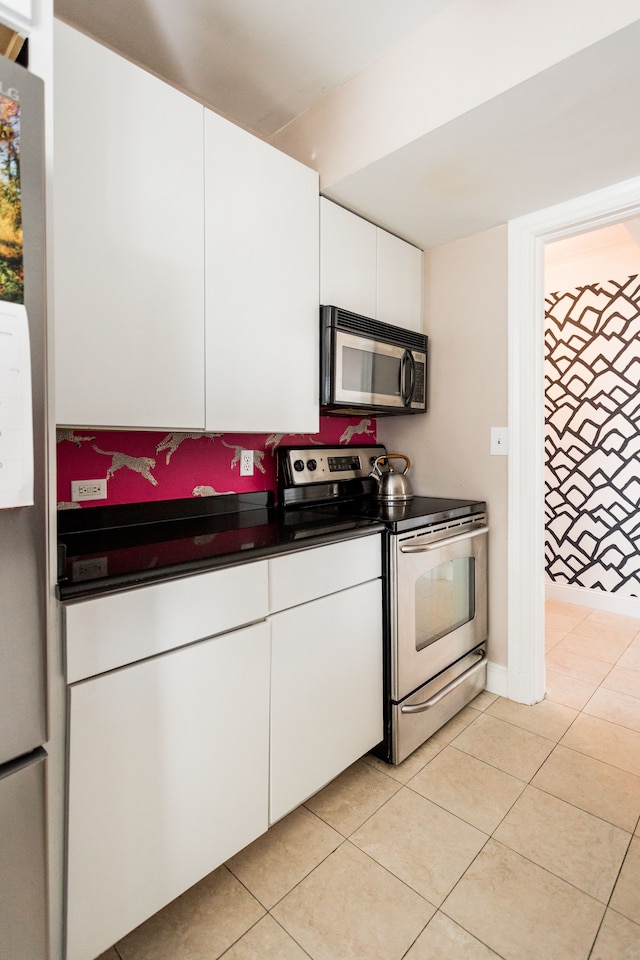 kitchen featuring light tile patterned flooring, white cabinetry, and stainless steel appliances