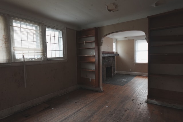 unfurnished living room with dark hardwood / wood-style flooring and a fireplace