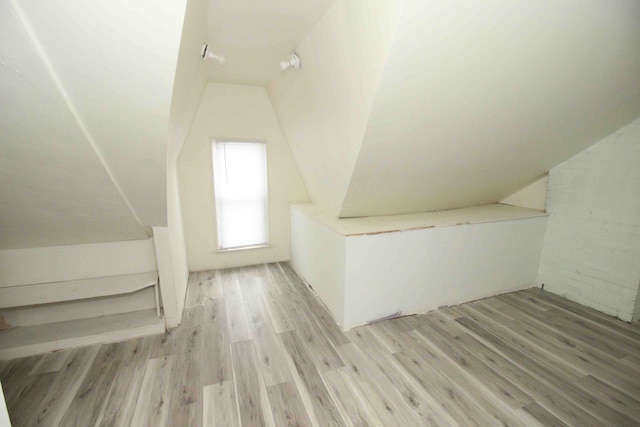 bonus room with light hardwood / wood-style floors and vaulted ceiling