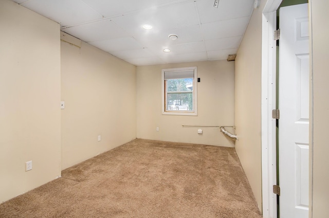 carpeted empty room with a paneled ceiling