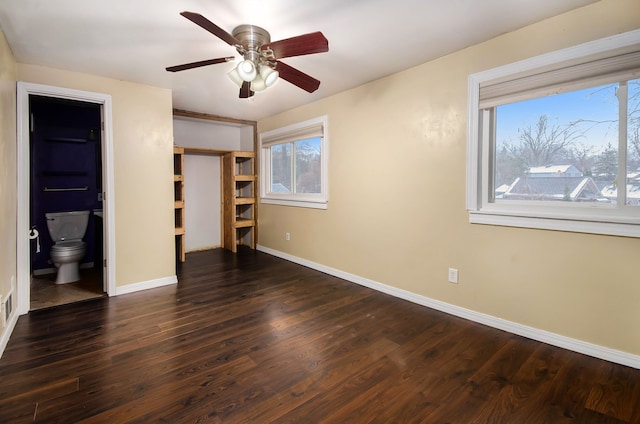 unfurnished bedroom featuring ensuite bath, ceiling fan, and dark hardwood / wood-style flooring