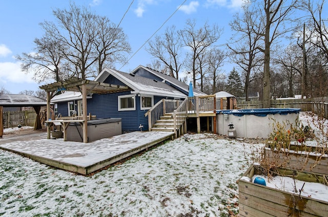 snow covered house with a swimming pool with hot tub and a pergola