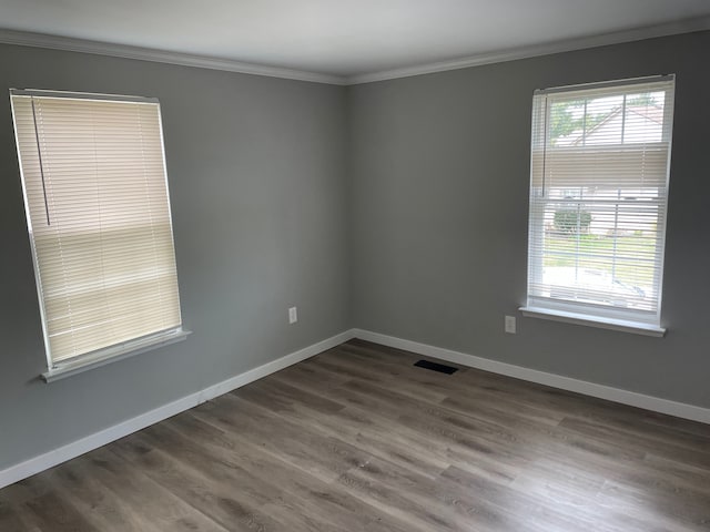 empty room featuring dark hardwood / wood-style flooring and ornamental molding