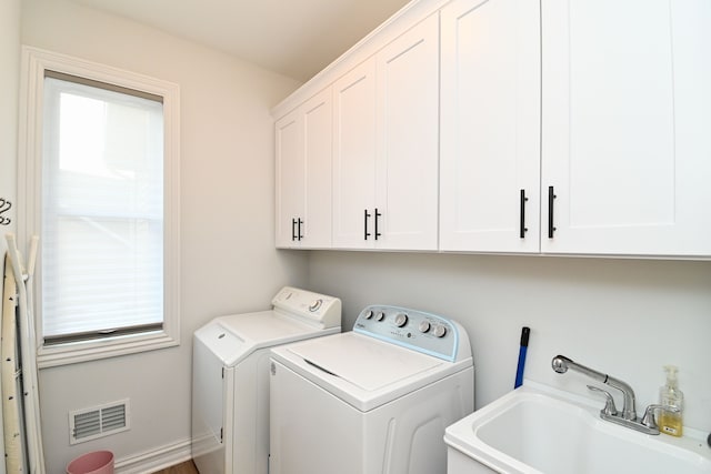 laundry room with cabinets, washing machine and dryer, and sink