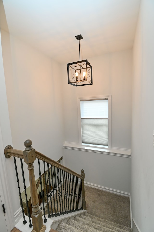 stairs featuring carpet flooring and a notable chandelier