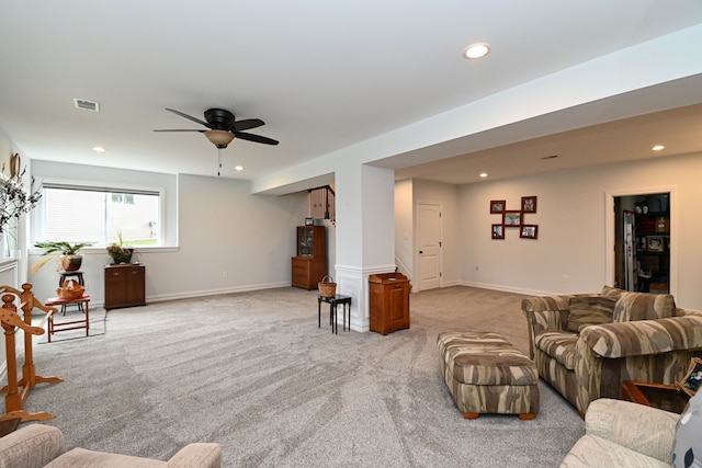 carpeted living room with ceiling fan