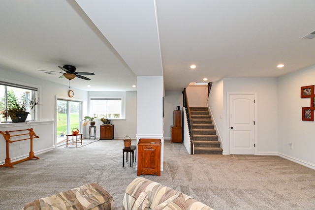 carpeted living room with ceiling fan