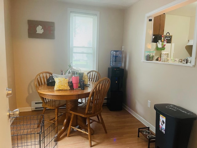 dining space with wood-type flooring and baseboard heating