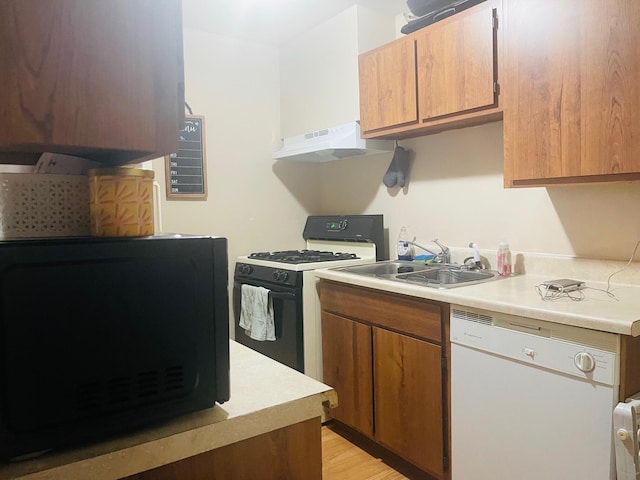 kitchen featuring sink, light wood-type flooring, white appliances, and ventilation hood