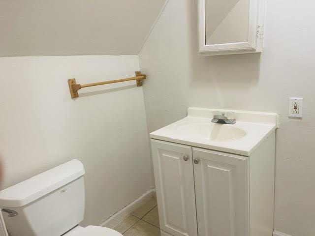 bathroom with tile patterned flooring, vanity, and toilet