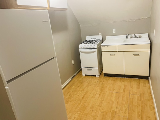 kitchen featuring light hardwood / wood-style flooring, white appliances, and sink