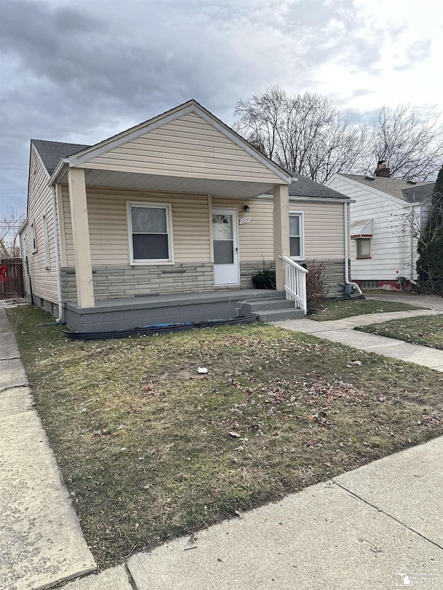 view of front of home featuring covered porch and a front yard