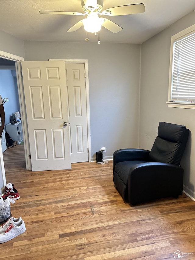 living area with ceiling fan and light wood-type flooring