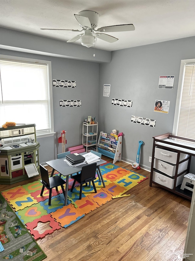 recreation room with ceiling fan and hardwood / wood-style flooring