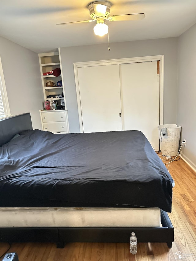 unfurnished bedroom featuring ceiling fan, a closet, and wood-type flooring