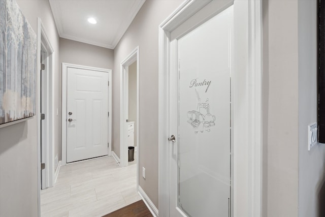 hallway featuring light wood-type flooring and ornamental molding