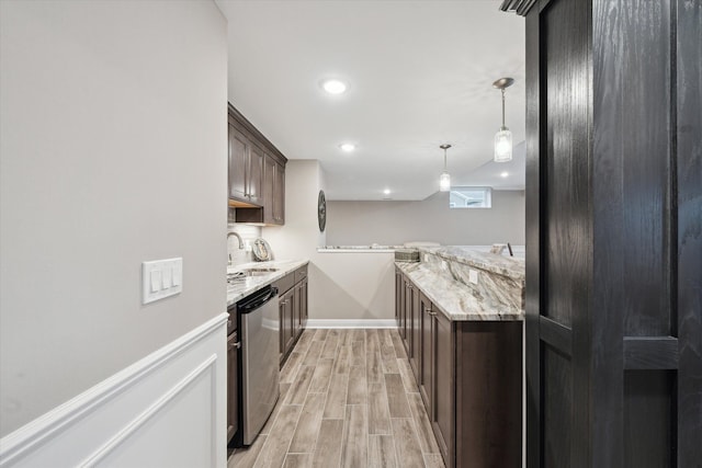 kitchen featuring light stone counters, stainless steel dishwasher, dark brown cabinets, sink, and pendant lighting