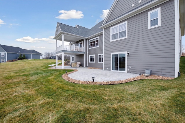 rear view of property with a patio, a balcony, and a lawn