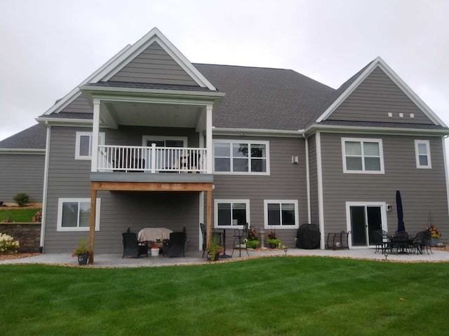 rear view of house featuring a lawn, a patio area, and a balcony