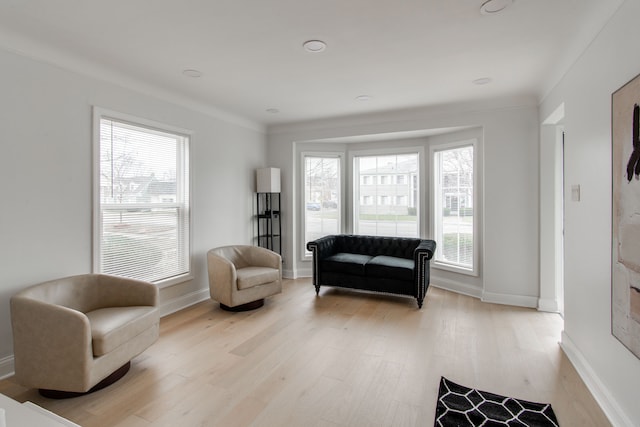 sitting room featuring a wealth of natural light, crown molding, and light hardwood / wood-style floors