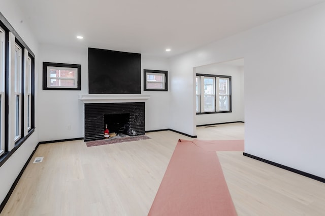 unfurnished living room with a fireplace and light hardwood / wood-style flooring