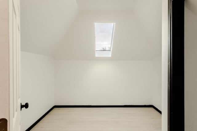 bonus room with light hardwood / wood-style floors and vaulted ceiling with skylight