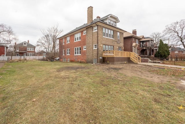 rear view of property with a yard and a wooden deck