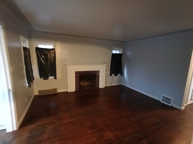 unfurnished living room featuring a fireplace and dark wood-type flooring