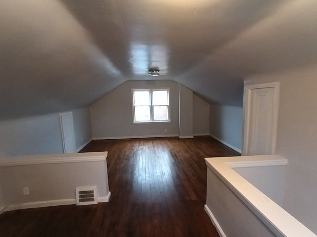 additional living space featuring dark hardwood / wood-style flooring and vaulted ceiling