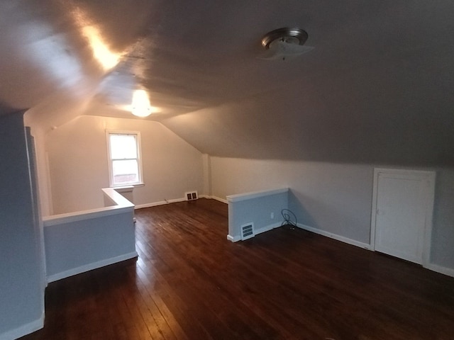 bonus room with dark wood-type flooring and lofted ceiling